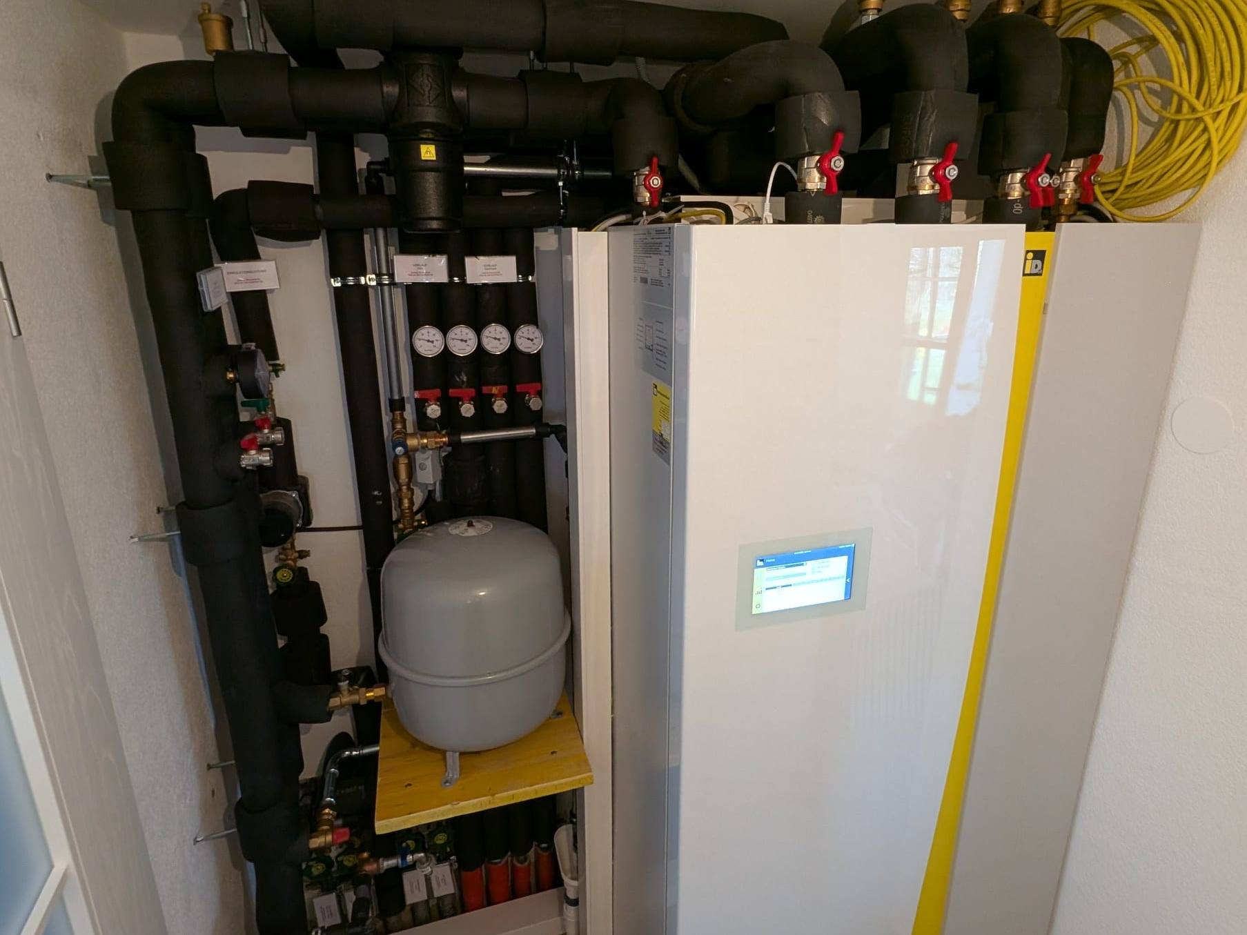 Wärmepumpen-Innengerät von iDM mit Display neben gedämmter Heizungshydraulik und Ausdehnungsgefäß