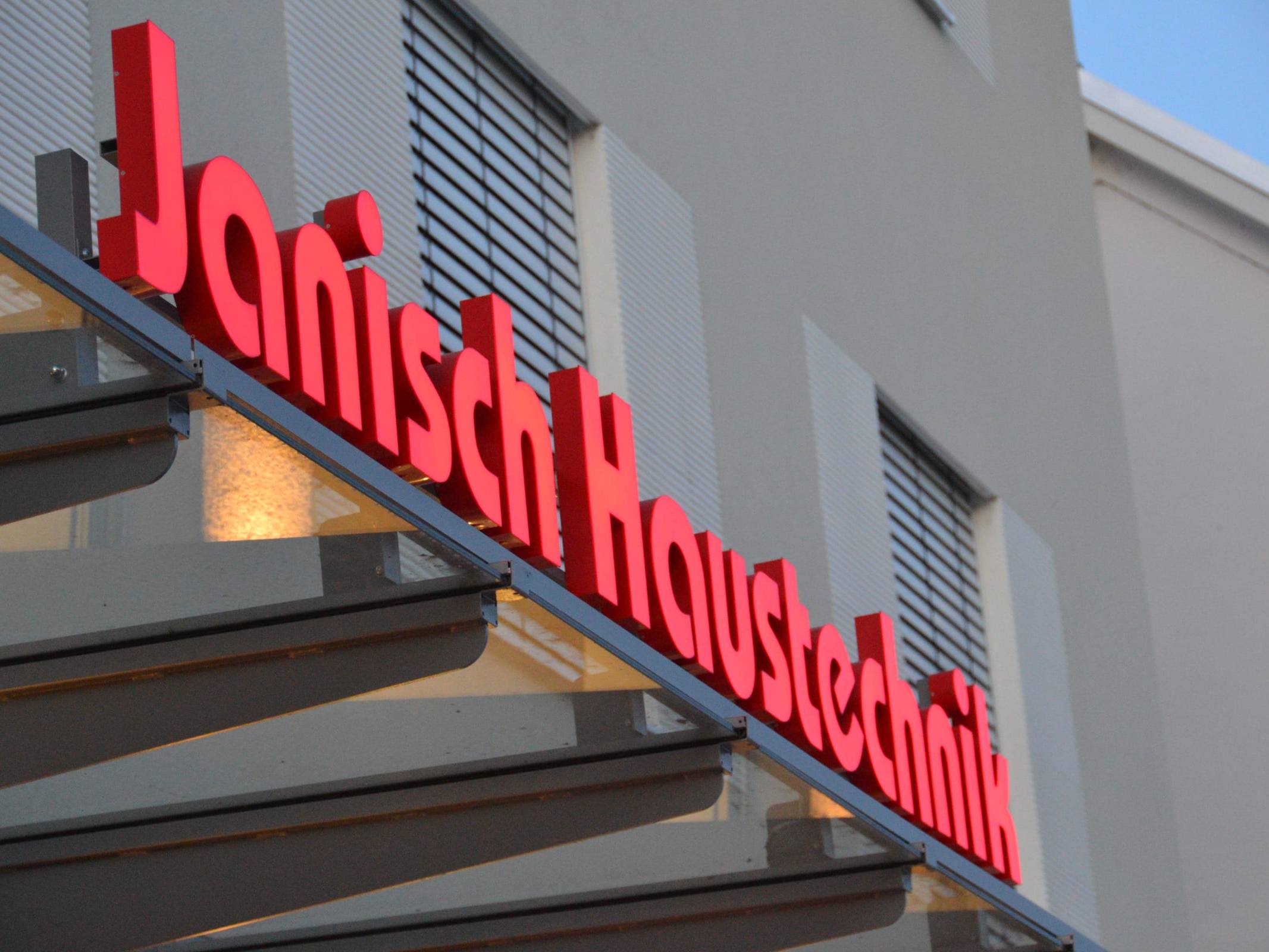 Roter Schriftzug Janisch Haustechnik über dem Vordach in Ilz 150