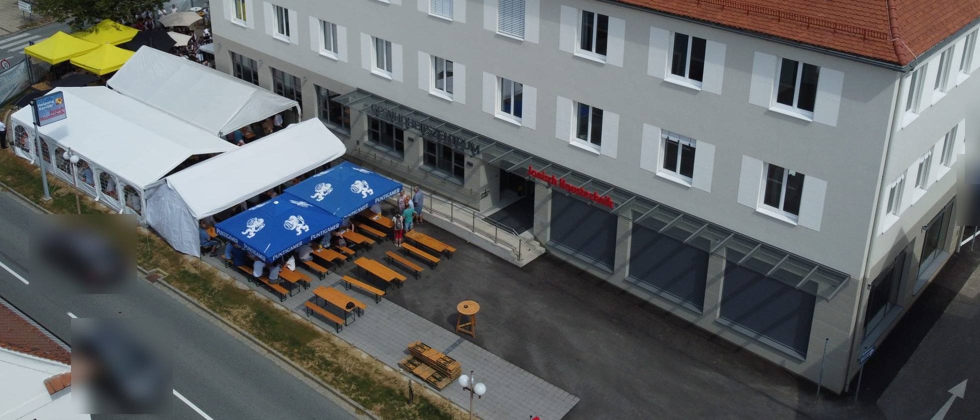 Luftbild des renovierten Hauptgebäudes Ilz 150 mit dem Schriftzug Janisch Haustechnik über dem Eingang, davor Festzelte von der Eröffnung im Juli 2026