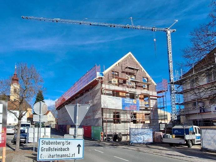 Eingerüsteter Altbau von Ilz 150 mit Baukran an der Straße, blauer Himmel
