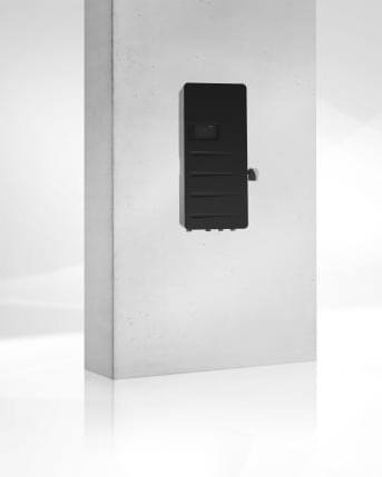 Fernwärme-Übergabestation TransTherm fit von Hoval mit grauer Verkleidung an einer Wand, Herstellerbild