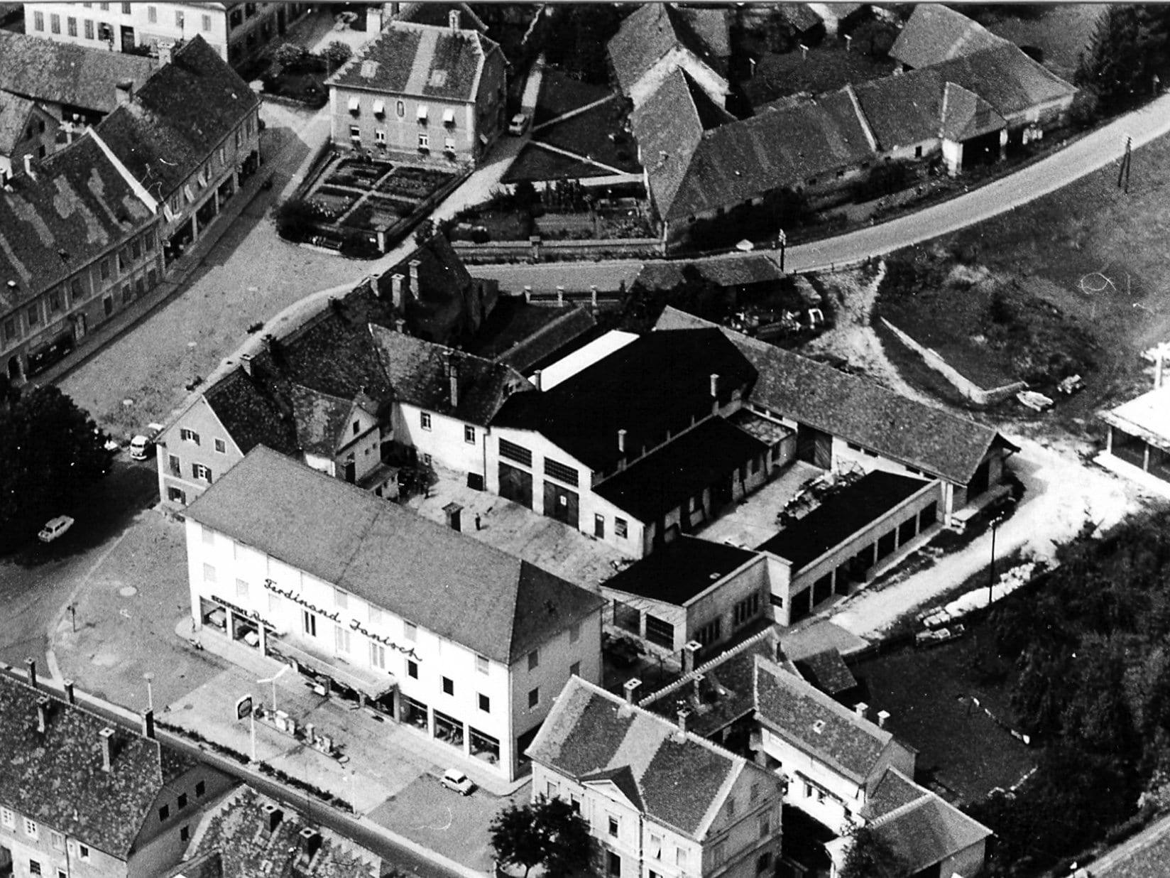 Historisches Luftbild mit dem Geschäftshaus „Ferdinand Janisch“, Zapfsäulen und Werkstatthallen