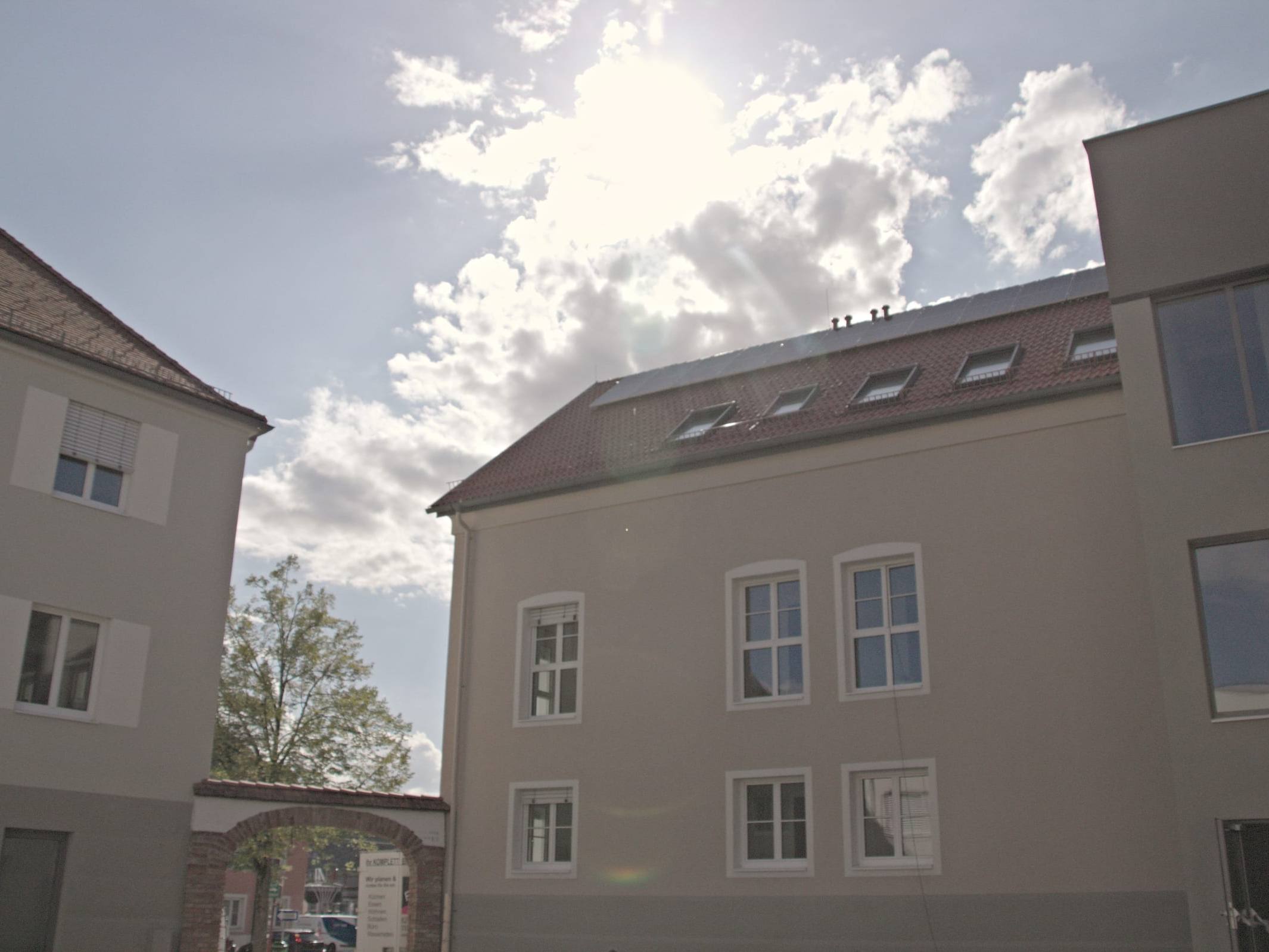 Innenhof des Gesundheitszentrums Ilz 150 mit renoviertem Altbau und neuem Zubau unter blauem Himmel