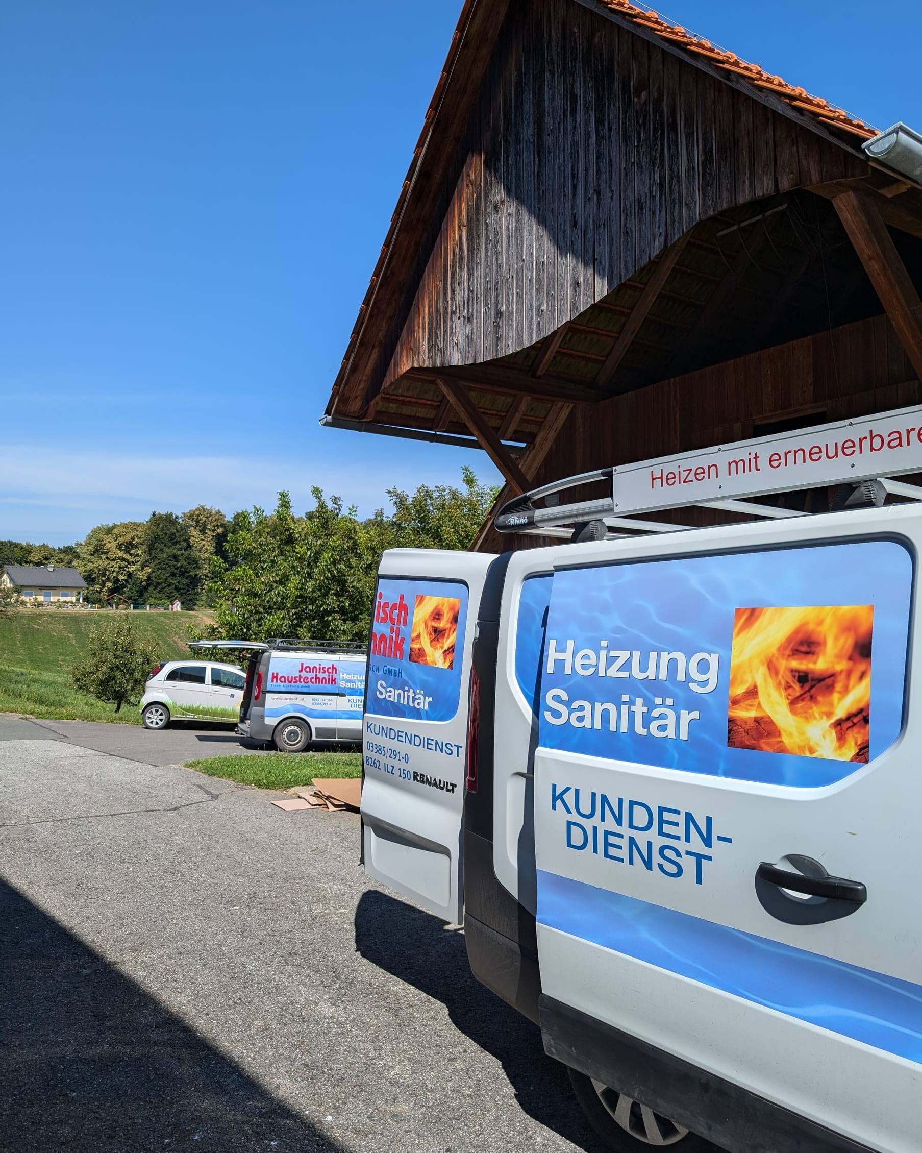 Kundendienst-Servicebus von Janisch Haustechnik vor einem Holzstadel, blauer Himmel